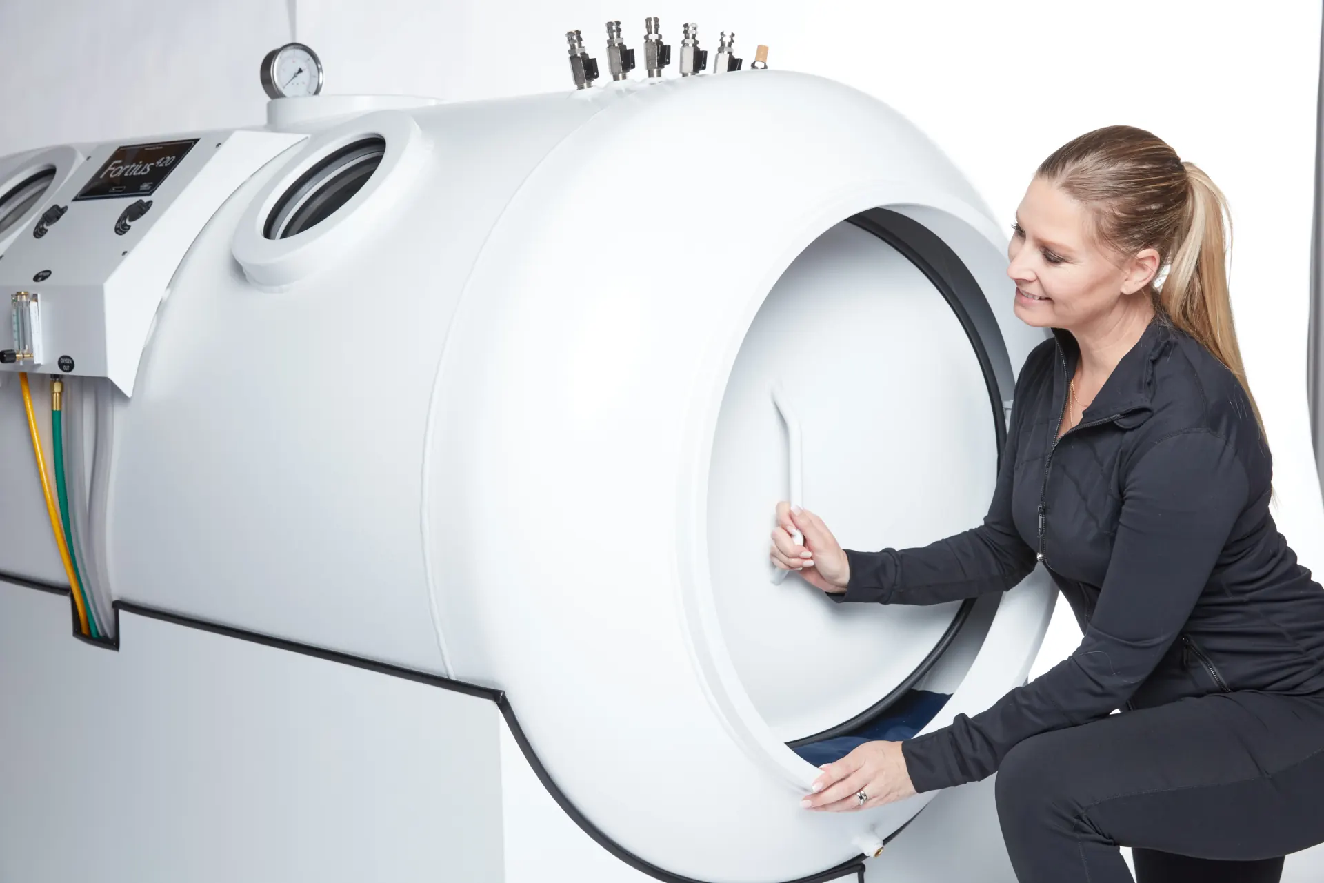 Woman stepping into an OxyHealth Fortius 420 hyperbaric chamber