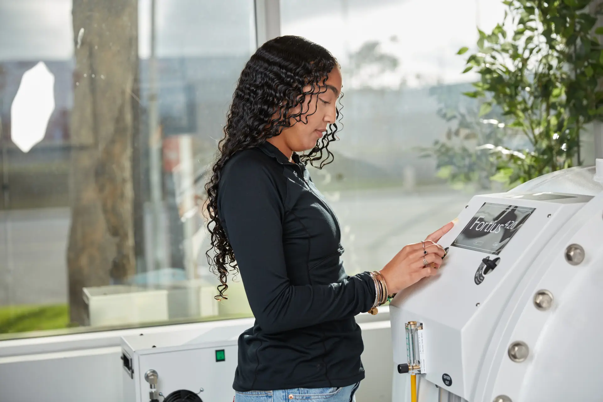 Practitioner using the touchscreen controls of an OxyHealth Fortius 420 EXP clinical hyperbaric chamber