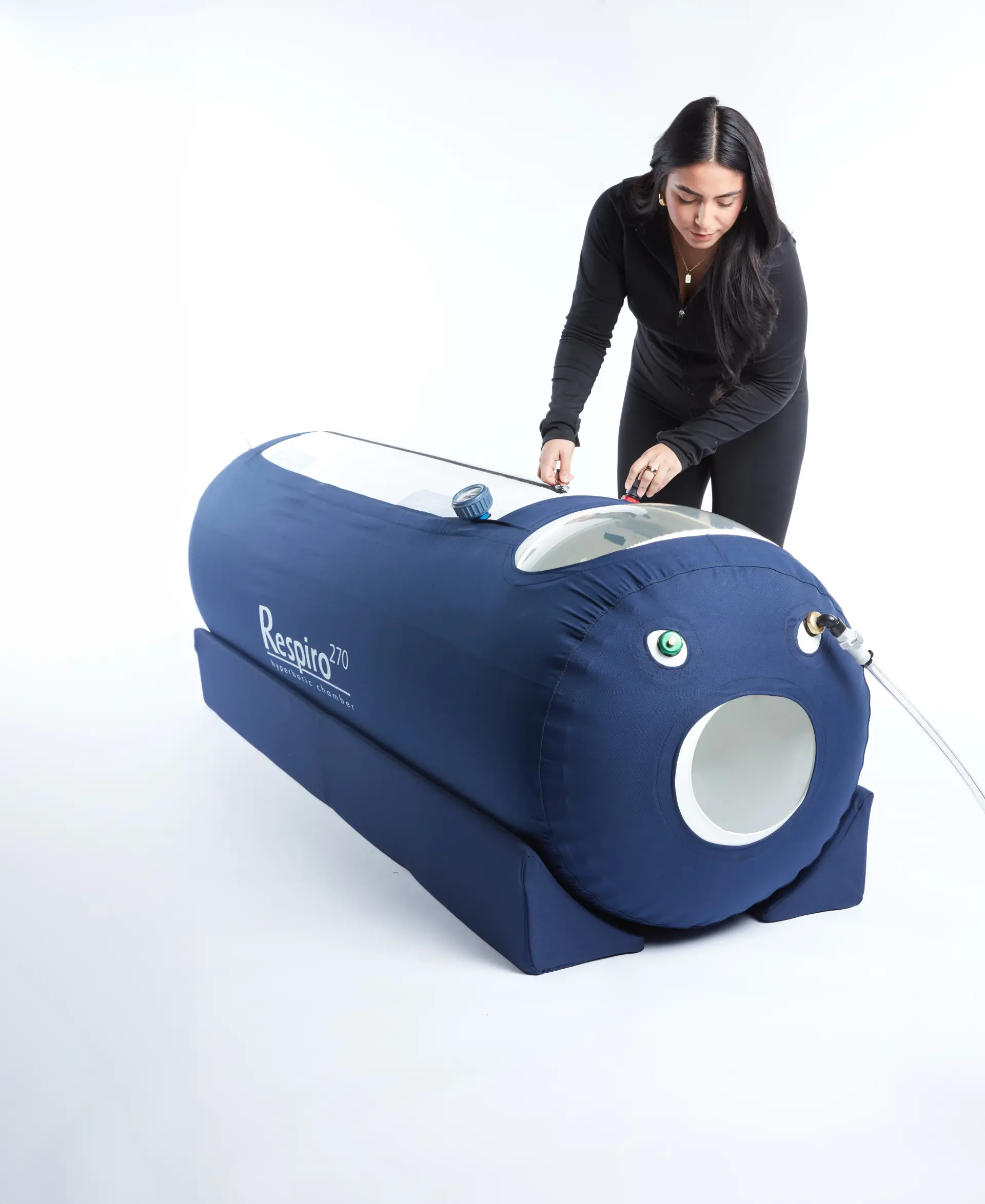 Woman with OxyHealth Respiro 270 compact portable hyperbaric chamber in home wellness setting