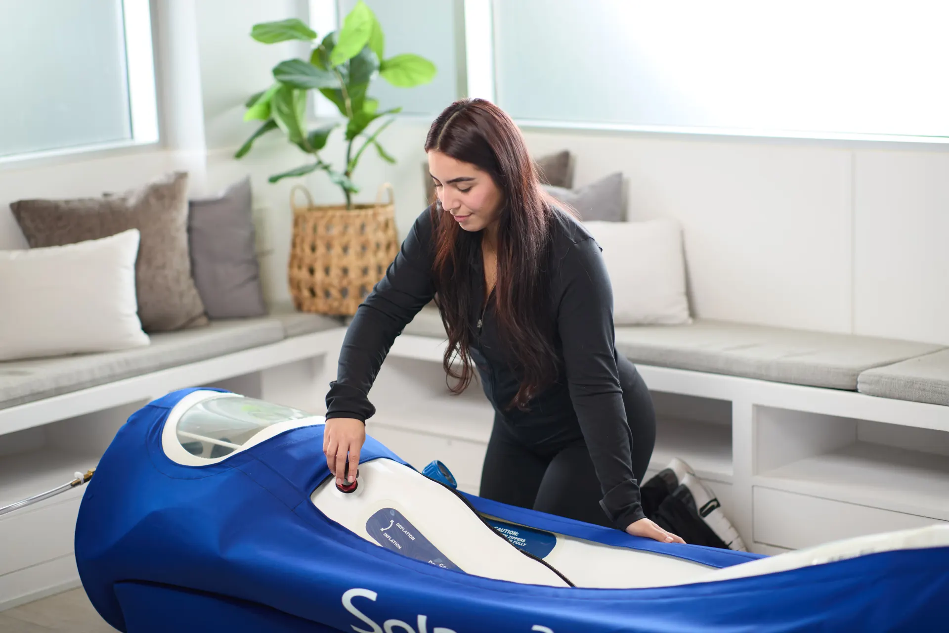 Woman with OxyHealth Solace hyperbaric chamber in comfortable home wellness environment
